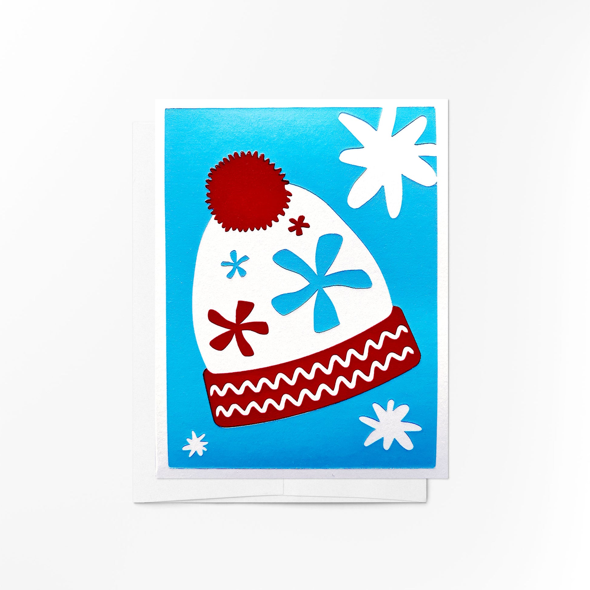 A vibrant holiday card featuring a cozy winter beanie decorated with twinkling stars and snowflakes on a blue background.