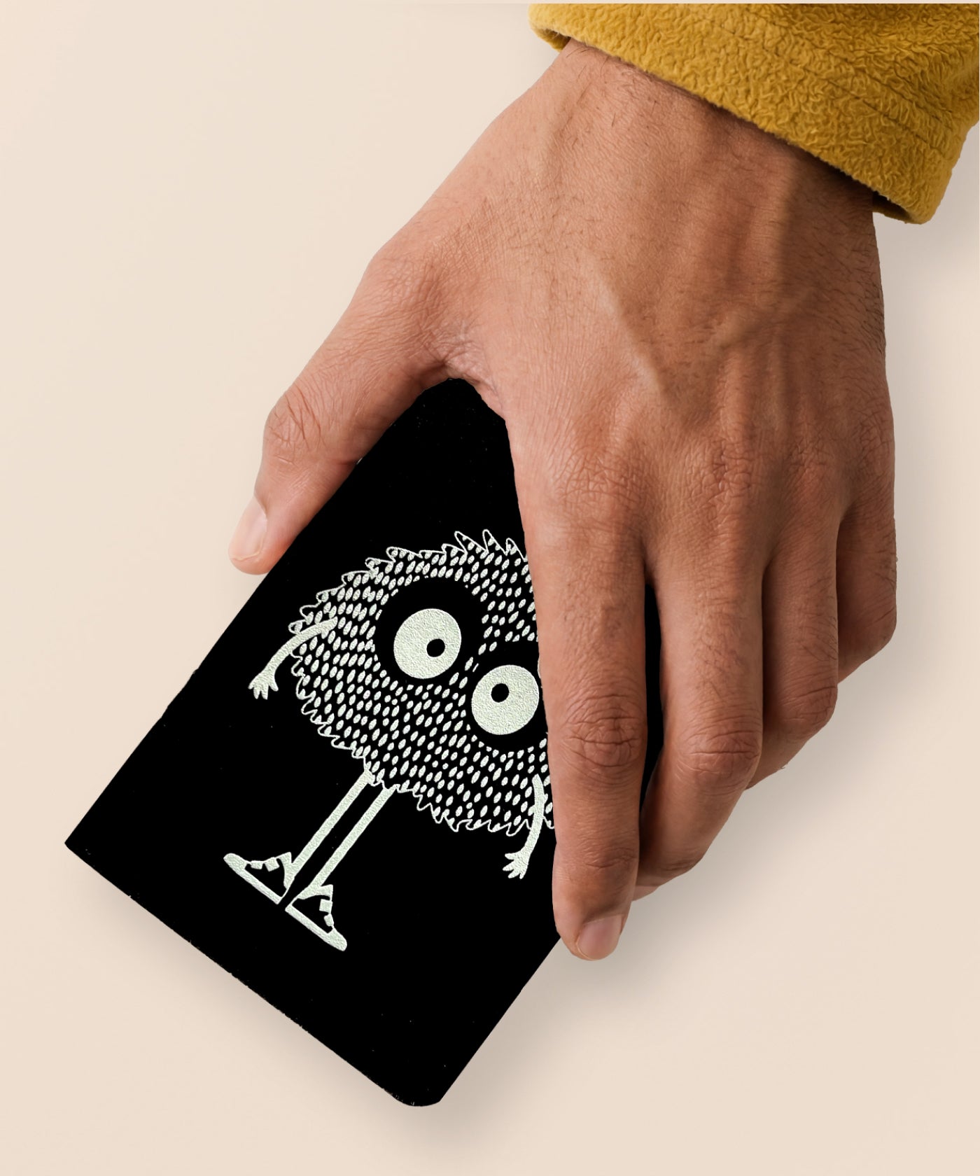 Hand holding a McWu screen-printed pocket notebook